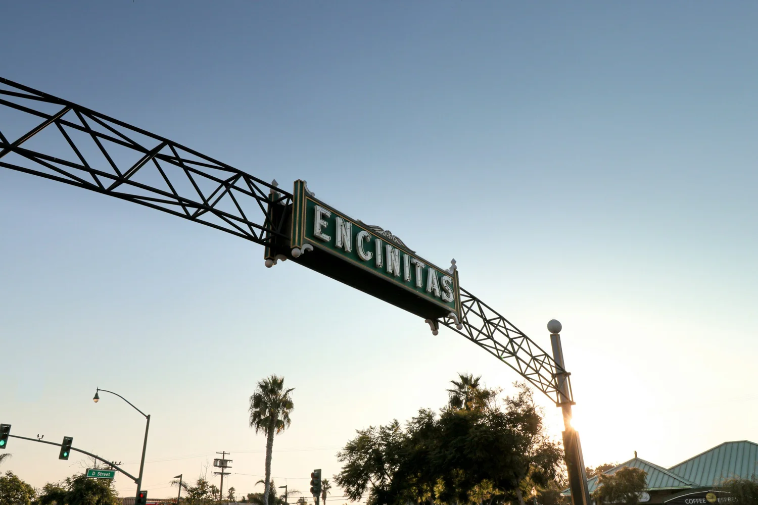 The iconic ENCINITAS sign over Coast Highway 101 with palm trees and clear sky