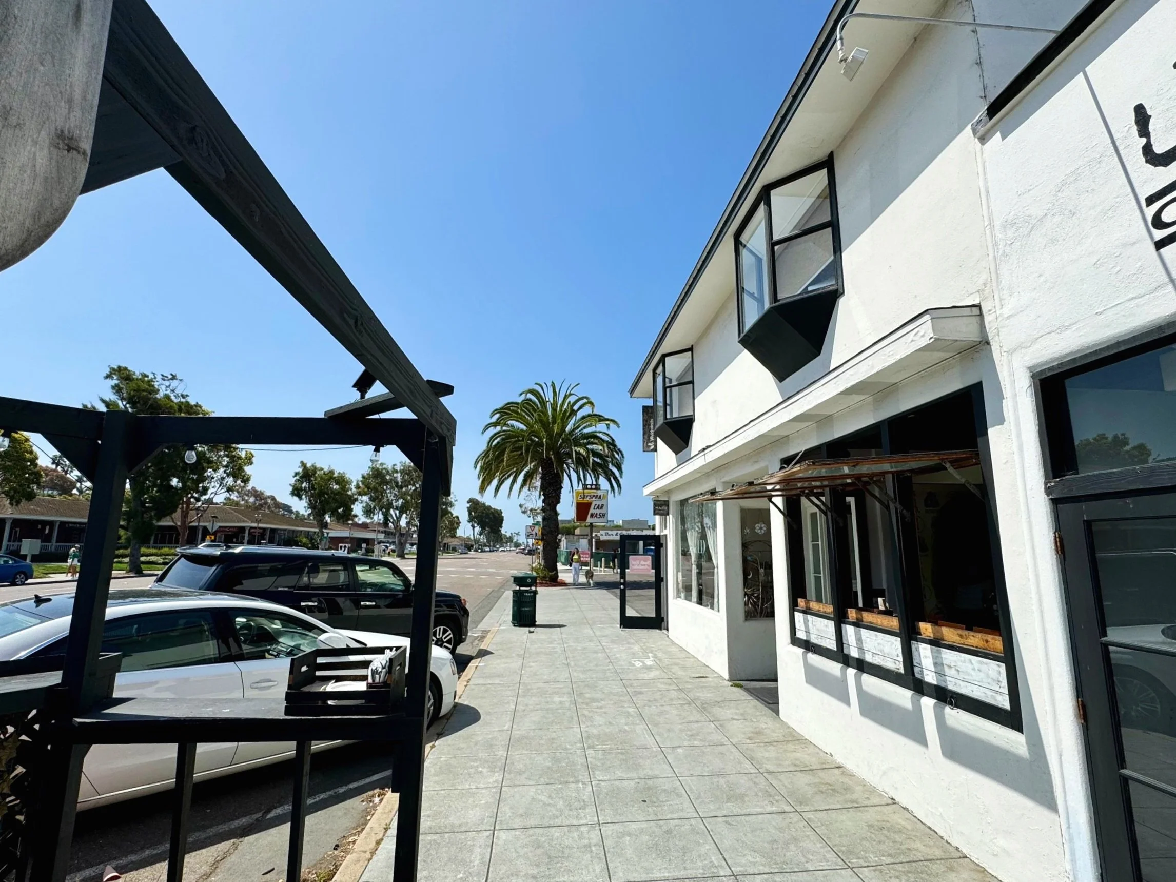 Sidewalk view of the Encinitas Coworking building on Coast Highway 101 with palm trees