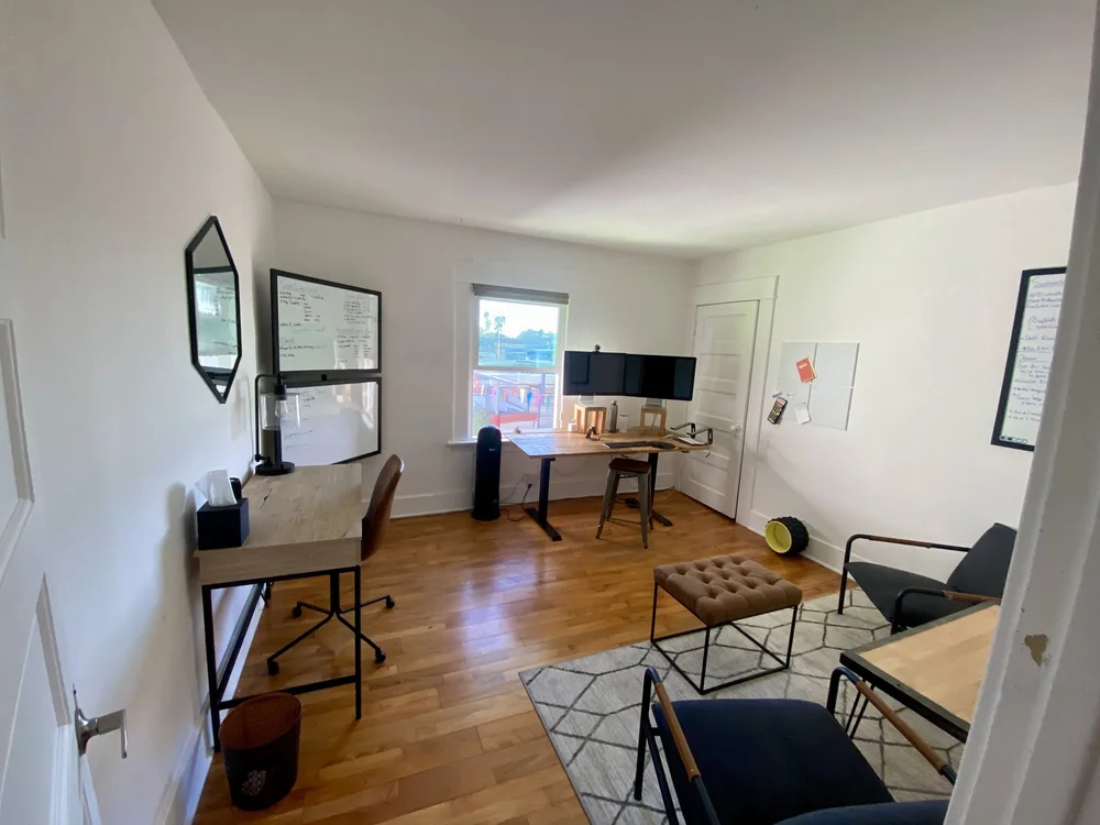Home office with a wooden desk set up for multiple monitors